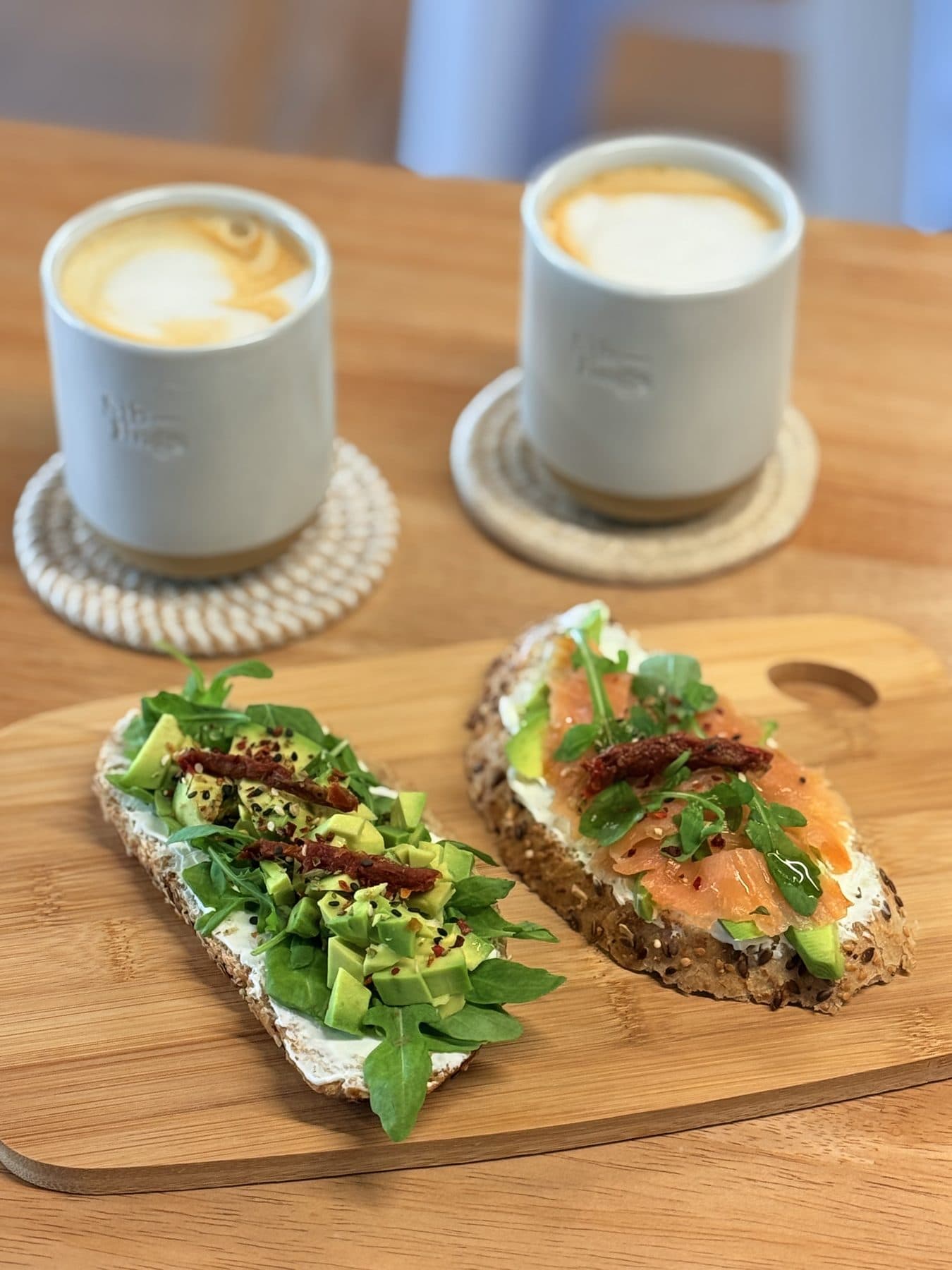 Desayuno de HŌKŌ con tostadas de aguacate y salmón ahumado y dos cafés