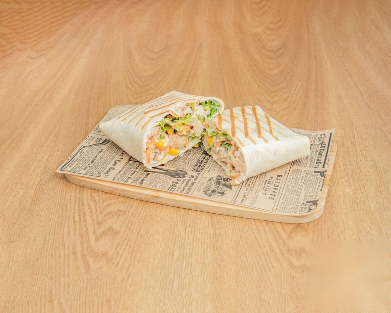 Wrap de HŌKŌ Poke cortado por la mitad sobre tabla de madera